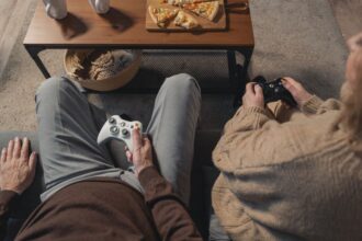 elderly playing video games senior holding game controller - ゲーム業界の次なる市場は高齢者? シニアゲーマーが変革の鍵