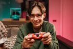 Young man playing video games in dark room, Military style youth camp - ゲーム依存息子を矯正施設へ…中国で起きた親子の悲劇